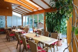 un ristorante con tavoli, sedie e finestre di Hotel Arcus a Elsterwerda