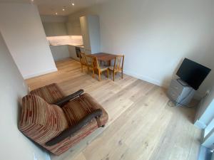 a living room with a couch and a tv and a table at One bedroom apartment with large balcony in Swanley Junction +5 photos