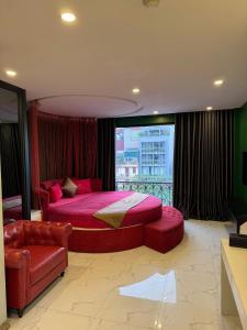 a bedroom with a red bed and a red chair at Golden Hotel in Hanoi