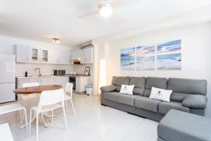 a living room with a couch and a table and a kitchen at El Médano Beach Apartment, Central & Bright in El Médano +19 photos