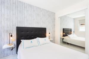 a bedroom with a large white bed and a mirror at El Médano Beach Apartment, Central & Bright in El Médano