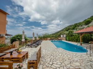 a resort with a swimming pool and tables and chairs at Apartments Scerbe Gordana & Miljenko Rab in Otok Rab