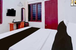a bedroom with a black and white bed and red doors at Hotel O Kallar Vattiyar Waterfalls Munnar in Munnar