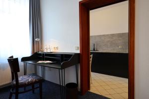 bagno con scrivania nera e specchio di Hotel Arcus a Elsterwerda Altre 42 foto