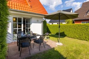 a patio with a table and an umbrella at Haus Kranichwiese in Zingst