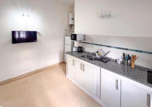 a kitchen with white cabinets and a sink at Refugio Del Corazón in Capilla del Monte +17 photos