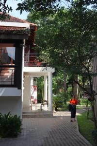 una donna che cammina lungo un marciapiede accanto a un edificio di Sala Baï Hotel & Restaurant School a Siem Reap