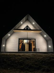 a house with lights on the front of it at night at Barn&Haus-Stodoły Widokowe in Zubrzyca Dolna