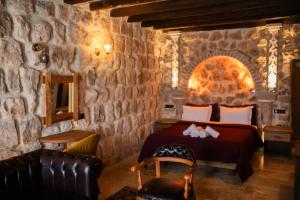 a bedroom with a bed and a stone wall at Rose Moon Cave in Macun Çiftliği