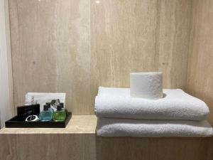 a pile of towels on a shelf in a bathroom at MSK Hotel 82 in London