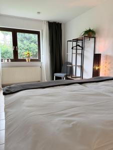 a white bed in a room with a window at Maison Kaiser - Studio apartment in Wadern