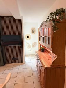 a living room with a wooden cabinet and a tv at Maison Kaiser - Studio apartment in Wadern