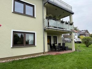a house with a balcony and a table and chairs at Maison Kaiser - Studio apartment in Wadern