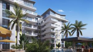 a large white building with palm trees in front of it at Big 1 Bedroom Apartment at Cantonments - Pool, Gym, Game Room in Accra