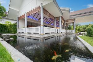 a house with a koi pond in front of it at Phuket La Siesta Pool Villas & Pool Access Rooms in Nai Harn Beach