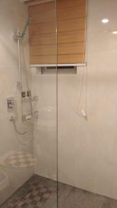 a shower with a glass door in a bathroom at Big 1 Bedroom Apartment at Cantonments - Pool, Gym, Game Room in Accra