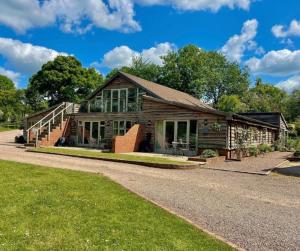 an old house with glass windows and a driveway at Swallows Lodge in Droitwich