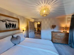 a bedroom with a white bed with a heart pillow on it at Lodge Rose's Heart in Bramberg am Wildkogel