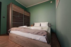 サモコフにあるRila Zen Apartmentの木製のヘッドボードが付いた大きなベッドのある寝室