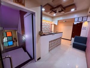 una habitación con un bar con una silla azul en Hotel SK Galaxy Thane West, en Thane