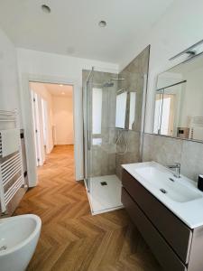 a bathroom with a white sink and a shower at Appartamento Èlite in Pordenone