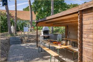 a outdoor grill with a table with food on it at Ferienanlage Sonneninsel Haus Himmelblau Erdgeschoss in Loddin