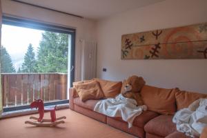 a teddy bear sitting on a couch in a living room at CAMPIGLIO Panorama sul Brenta in Madonna di Campiglio