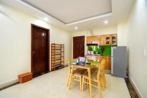 a kitchen with a table and a refrigerator at HQ Hotel & Apartment in Hai Phong