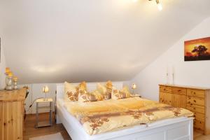 a bedroom with a large white bed with gold pillows at Ferienwohnungen Alt in Altenstädt