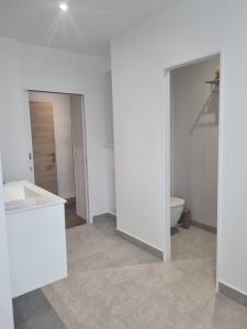a white bathroom with a sink and a toilet at Belle Chambre privée avec vue sur la montagne in Moncayolle-Larrory-Mendibieu
