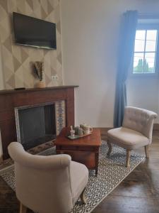 a living room with two chairs and a fireplace at Belle Chambre privée avec vue sur la montagne in Moncayolle-Larrory-Mendibieu