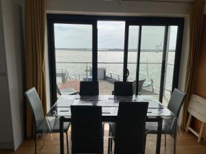 a dining room with a table and chairs and a large window at Ten Admiralty Pier in Shotley Gate