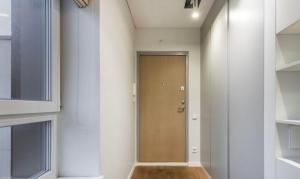 a hallway with a brown door in a room at Stilingas dviejų kambarių butas in Vilnius