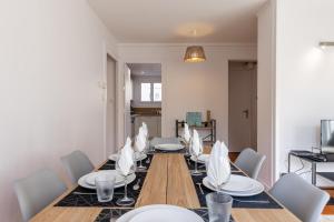 une salle à manger avec une table et des chaises en bois dans l'établissement Appartement 3 chambres - Gare - Centre-ville, à Bourg-en-Bresse 20 autres photos
