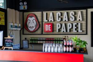 a bar with a sign that reads la casa de papel at Whoopers Hostel Ao Nang - By The Beach in Ban Khlong Haeng