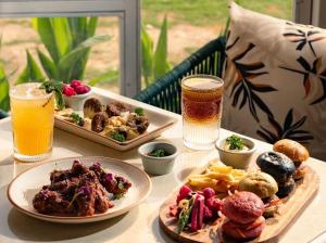 a table with plates of food and two glasses of beer at Torque Stays in Noida