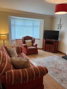 ein Wohnzimmer mit Sofa und Fernseher in der Unterkunft Moyle Manor in Ballycastle
