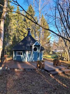 a small blue house sitting on a wooden deck at NorthSlope in Rovaniemi