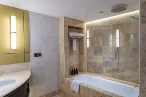 a bathroom with a tub and a sink at Mangkuluhur ARTOTEL SUITES in Jakarta +47 photos