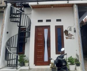 a motorcycle parked in front of a house with a door at Homestay Castanea in Diyeng +1 photo