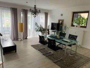 a living room with a glass table and chairs at Bezauberndes Gästehaus im Grünen mit Terrasse in Bad Wildbad +18 photos