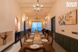 a long dining room with a long table and chairs at StayVista at Raga Living - Mountain Views, Bonfire in Parwanoo