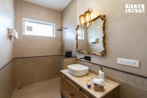 a bathroom with a sink and a mirror at StayVista at Raga Living - Mountain Views, Bonfire in Parwanoo +43 photos