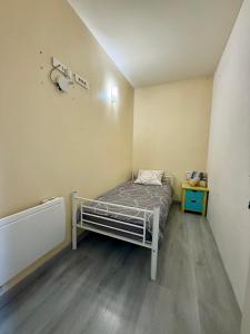 Una pequeña habitación de hospital con una cama dentro. en Face à la gare - Espace nuit privé 1, en Roanne