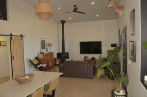 a living room with a couch and a tv at The Rusty Kangaroo - Premium Couples Retreat - Spectacular Ocean View - Great Hosts in Penneshaw