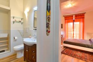 a bathroom with a sink and a toilet and a bed at Residenza La Donzella - Appartamento rosso in Campobasso
