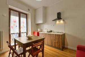 a kitchen with a table and chairs and a kitchen with a stove at Residenza La Donzella - Appartamento rosso in Campobasso