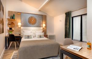 una habitación de hotel con una cama y un escritorio en Serotel Suites Opera, en París 26 fotos más