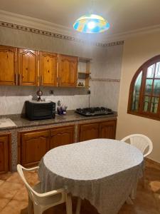 a kitchen with a table with chairs and a microwave at Villa nuira in Inezgane