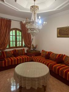 a living room with couches and a chandelier at Villa nuira in Inezgane